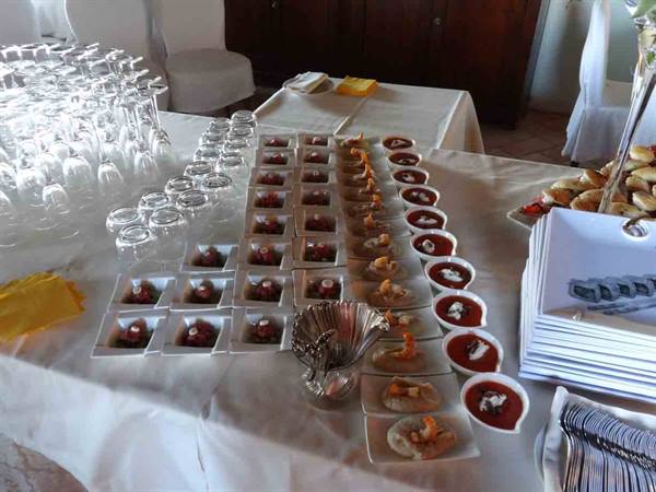 Banquet table set with glasses, tasting plates and appetizers