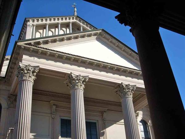 Corinthian columns and pediment of the neoclassical cathedral facade against blue sky