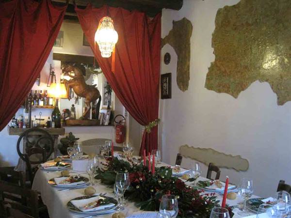 Set dining table with red candles and horse statue in a rustic restaurant