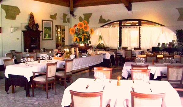 Restaurant dining room with white tablecloth tables and a sunflower arrangement
