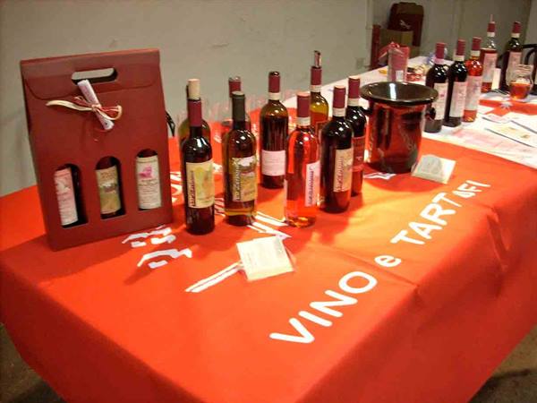Wine bottles displayed on a table with an orange VINO e TARTUFI tablecloth