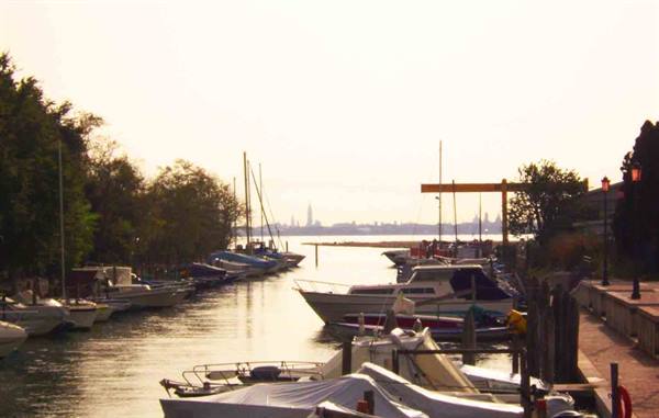 Boats moored along a Venice lagoon canal in golden light
