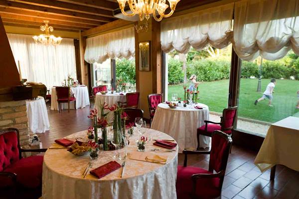 Restaurant dining room with set tables, red chairs and glass chandeliers
