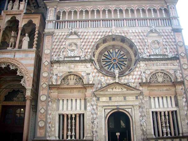 Marble facade of the Colleoni Chapel in Bergamo with rose window and statues