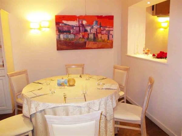 Set table in pink dining room with painted village picture on wall