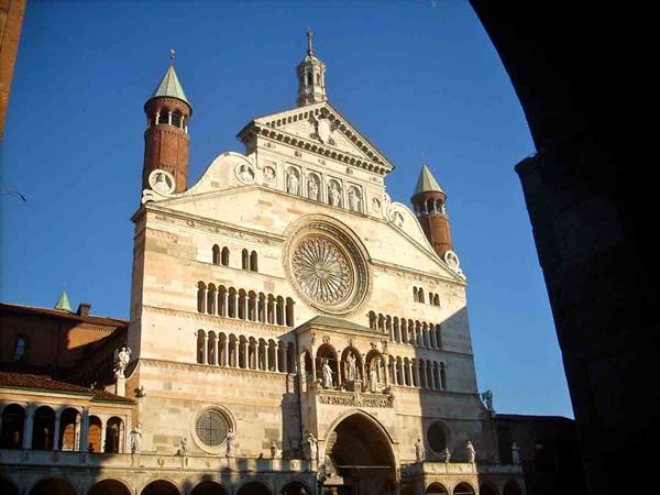 Romanesque facade of Cremona Cathedral with rose window, sunlight