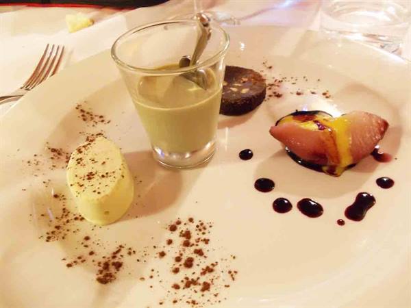 Dessert plate with cocoa panna cotta, cream shooter and syruped pear