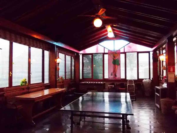 Wooden room with ping-pong table, glowing lamps and bright windows