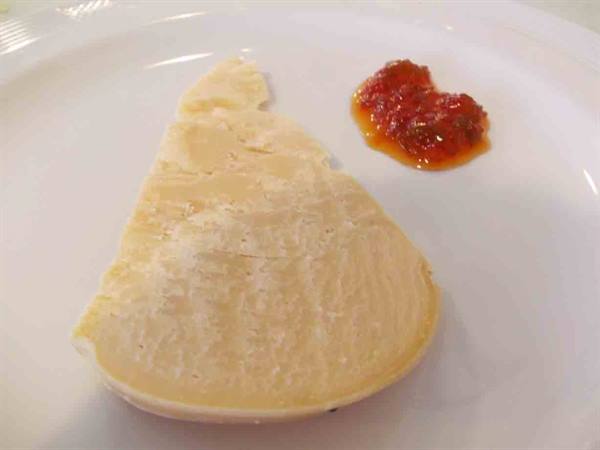 Cheese slice with spicy jam on a white plate