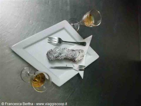 Powdered pastry on white plate with two wine glasses