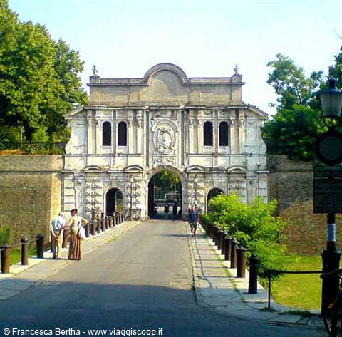 Tourists walk toward Porta Udine, the monumental stone gate of Palmanova