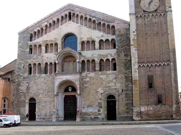 Romanesque stone facade of Parma Cathedral with brick bell tower