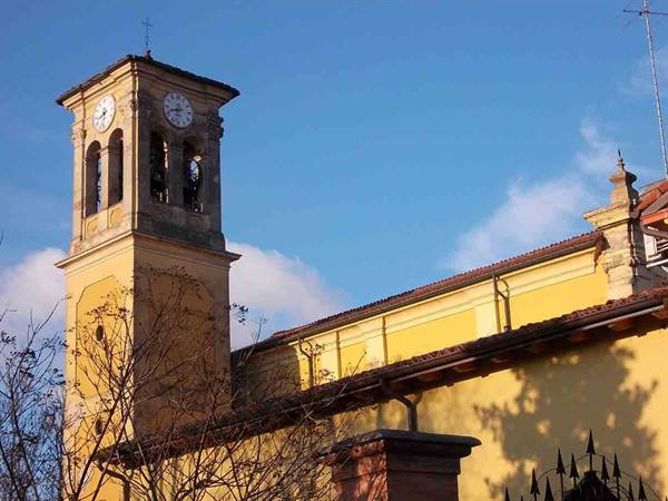 Clock bell tower and yellow church under blue sky