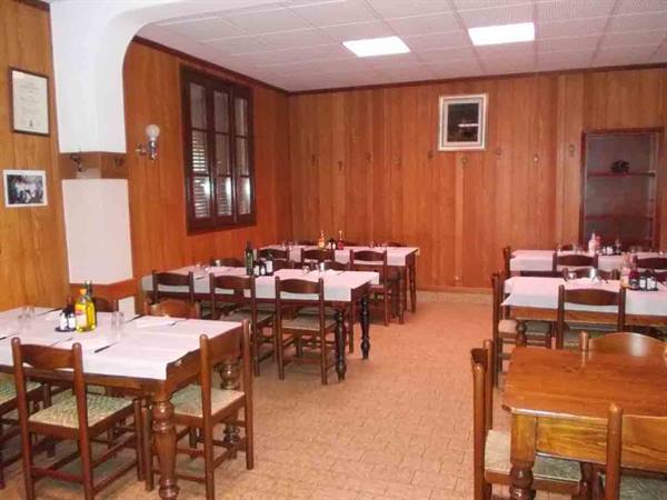 Empty dining room with wooden tables, white tablecloths and wood-paneled walls