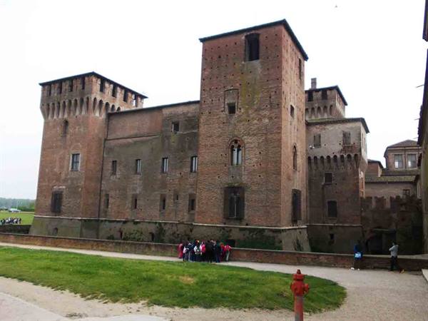 Tourists queueing before the Rocca Sanvitale in Fontanellato, red brick walls under grey sky