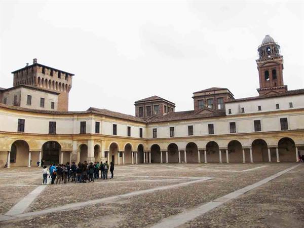 Tourists gathered in the cobbled courtyard of Palazzo Ducale, Mantua