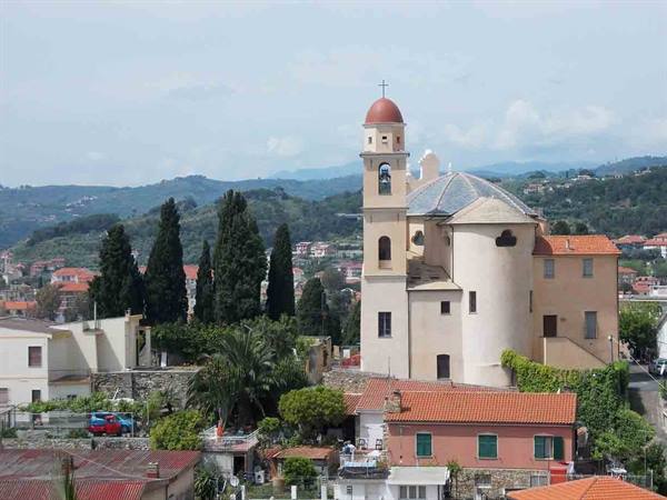 Church with red dome and bell tower among hills, tiled roofs