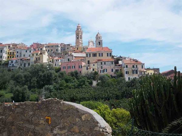 Cervo hilltop village with pastel houses and bell towers above stone wall