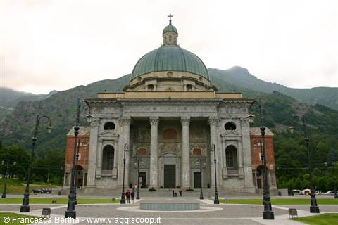 Oropa Sanctuary: marble facade and green dome amid misty mountains