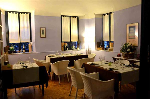 Restaurant dining room with set tables, white chairs and curtained windows