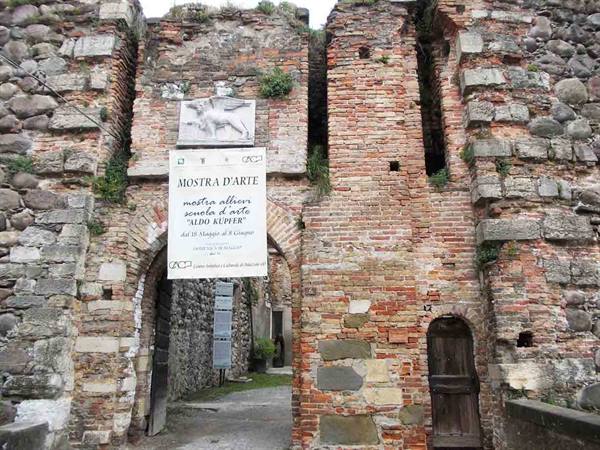 Ancient brick and stone gateway with art exhibition banner
