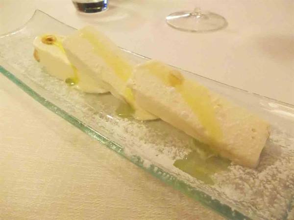 White dessert on glass plate with powdered sugar and syrup