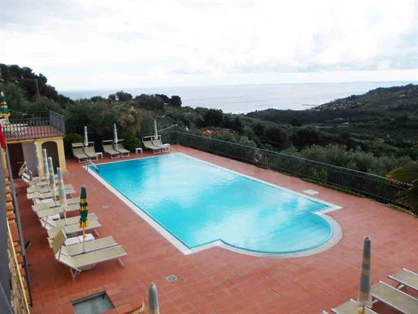 Pool with loungers and umbrellas on a terrace above the sea