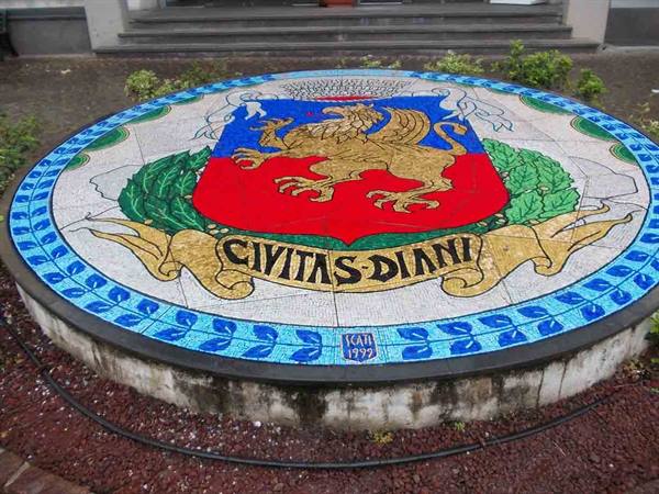 Circular mosaic with red griffin coat of arms reading Civitas Diani