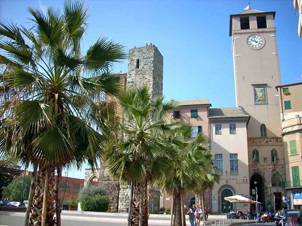 Palms in front of the clock tower and medieval stone tower in Rapallo square