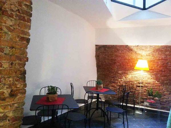 Black iron tables and chairs with plants, brick walls, glowing lamp