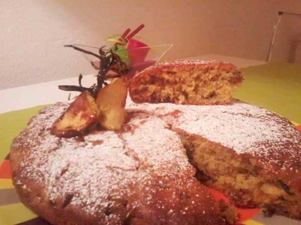 Homemade cake dusted with powdered sugar and apple slices
