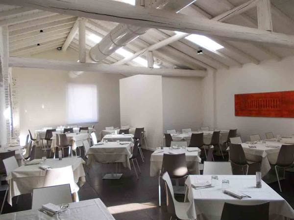 Empty restaurant dining room with set tables, white beams and skylights
