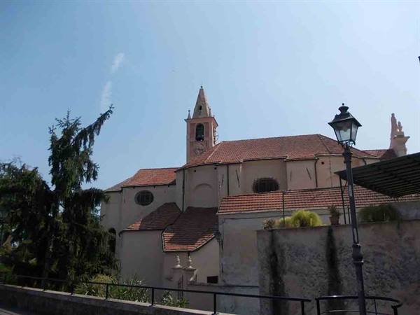 Church with bell tower and terracotta roofs, blue sky, street lamp nearby