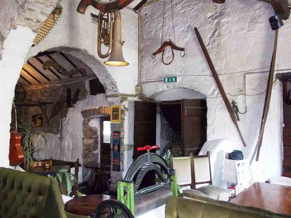 Old farmhouse interior with farm tools hanging on whitewashed walls