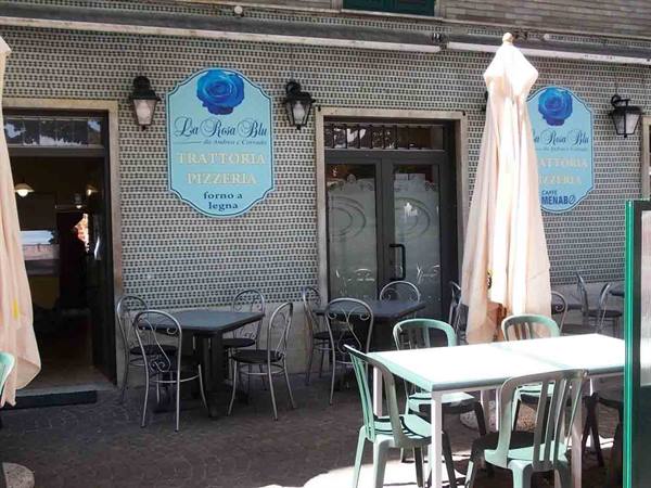 Empty tables and closed umbrella outside La Rosa Blu pizzeria