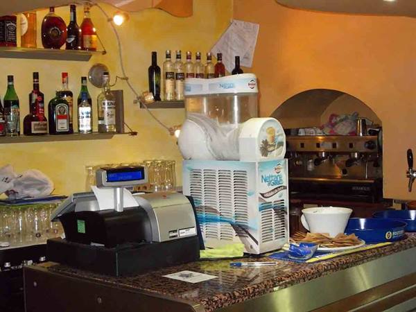 Bar counter with cash register, slush machine, bottles and espresso machine