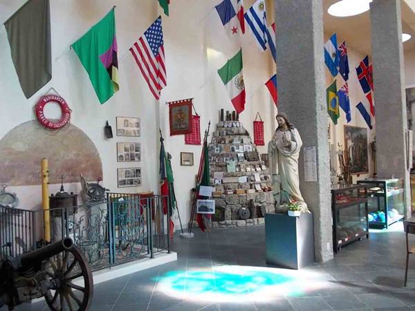 Museum hall with international flags, Jesus statue and antique cannon