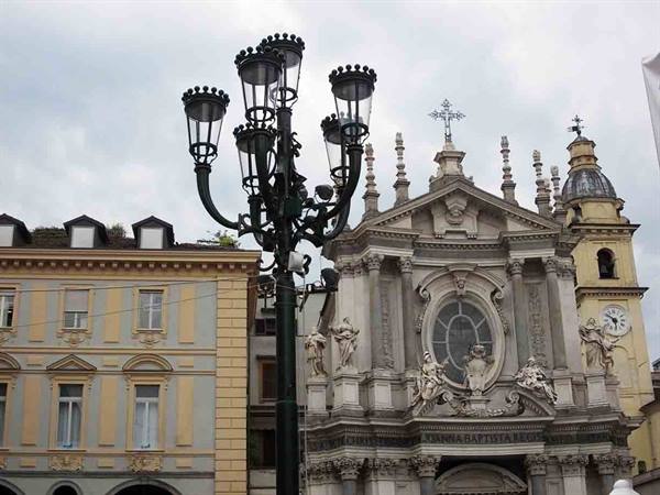 Green cast-iron lamppost in front of a baroque church with statues