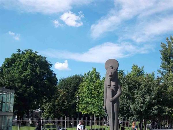 Stone statue of lioness goddess Sekhmet in a tree-lined park