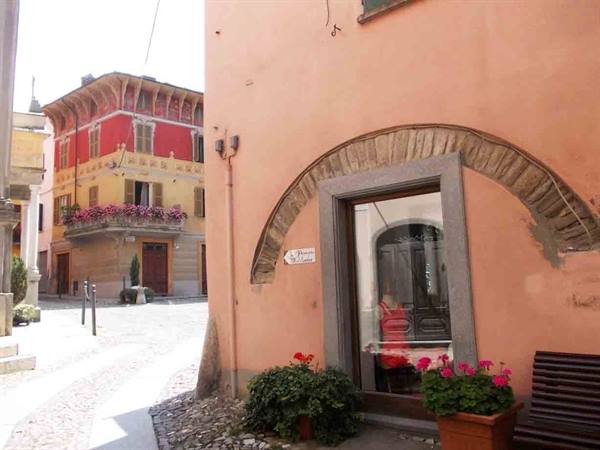 Colorful building with flowers and arched doorway on cobblestone street
