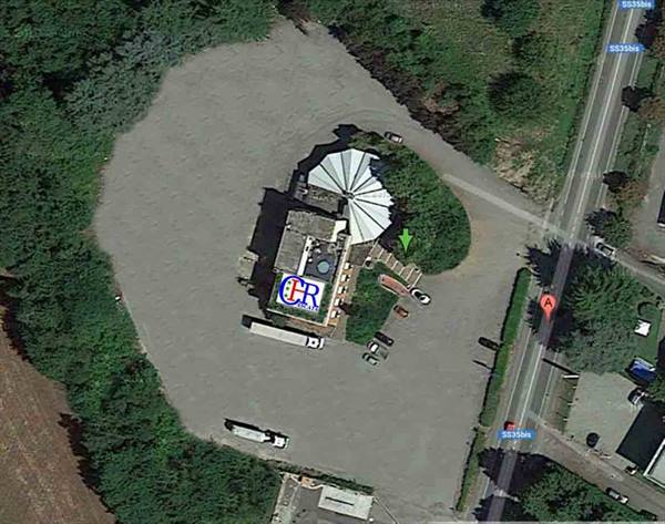 Aerial view of an umbrella-roofed restaurant with large parking lot
