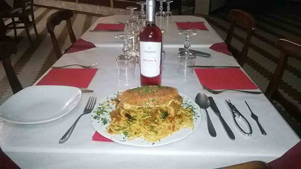 Spaghetti with crab dish and rosé wine bottle on a set table