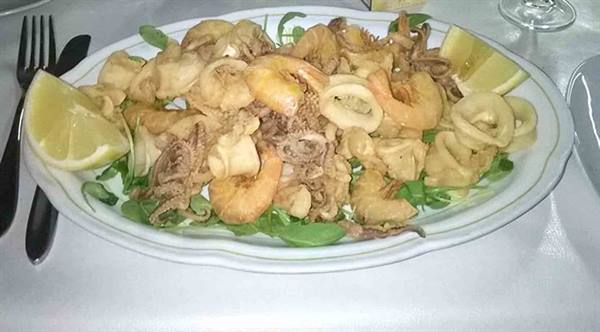 Fried calamari and shrimp platter with lemon wedges and arugula