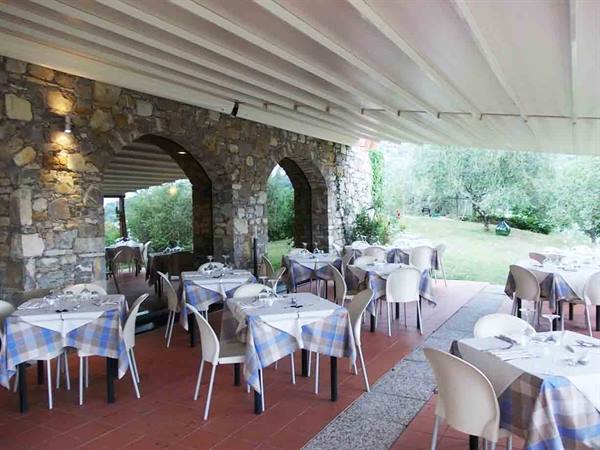 Restaurant terrace with set tables, checkered tablecloths and stone arches
