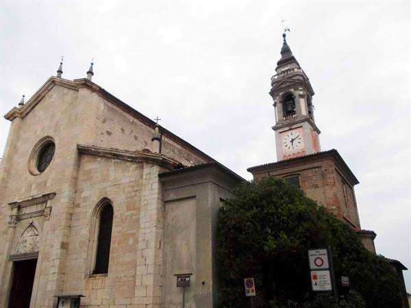 Stone church with clock bell tower under grey sky