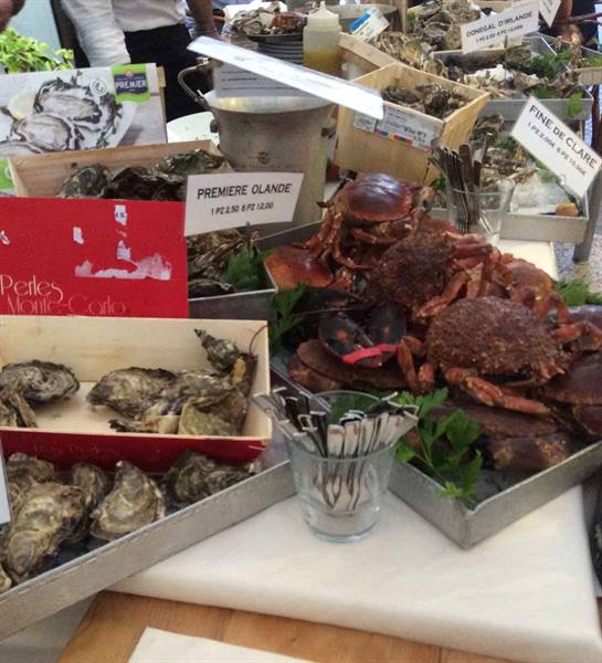 Fresh crabs and oysters in wooden crates at the fish market stall