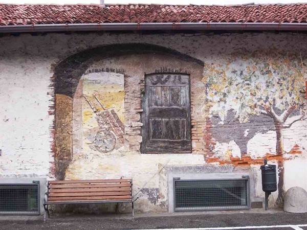 Wooden bench against a painted wall mural with tree and doorway
