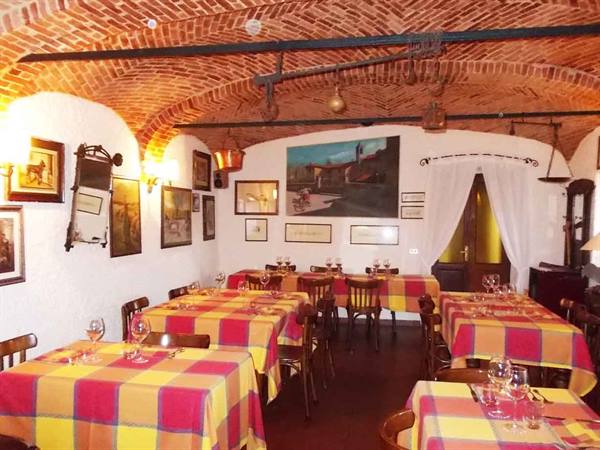 Trattoria dining room with brick vaulted ceiling, tables set with yellow and red checkered cloths