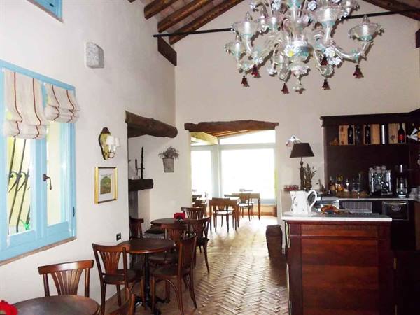 Interior hall with Murano glass chandelier, wooden tables and counter