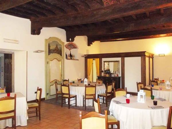 Dining room with set tables, yellow chairs and exposed wooden beams